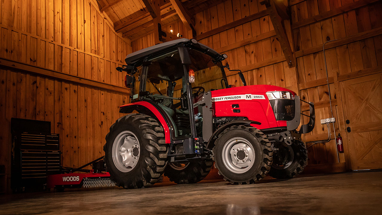 Massey Ferguson 2800M compact utility tractor with Woods cutter parked in barn, built for durability, comfort, and versatile farm work.