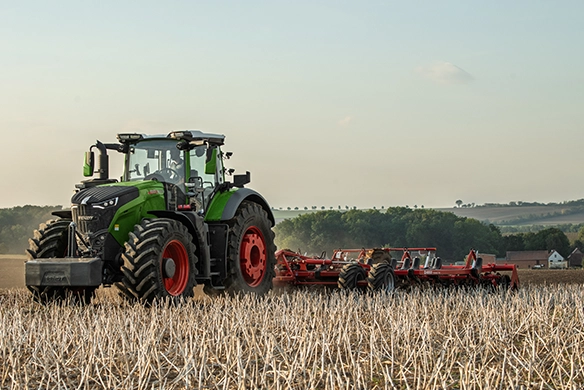 Fendt 1000 Vario tractor pulling a Sunflower tillage implement in a harvested field during daylight hours.