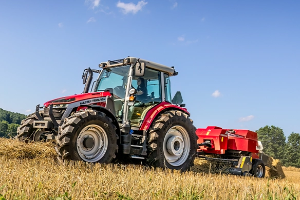 Massey Ferguson 5S Series tractor pulling a Hesston by Massey Ferguson 1800 Series small square baler through a straw field.