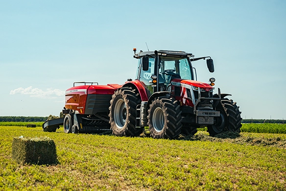 Massey Ferguson 6S Series high-horsepower tractor pulling Hesston by Massey Ferguson SB.1436DB double square baler in alfalfa field.