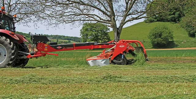 Kuhn FC 3561 TCD RA Center-Pivot Mower Conditioner with Merger mowing a field.