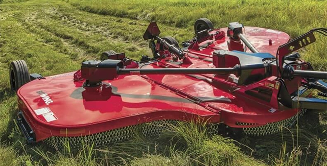 Close up of Woods Equipment bat-wing mower cutting a lush field of grass.