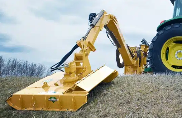 Diamond Mowers boom mower cutting grass along a roadside.