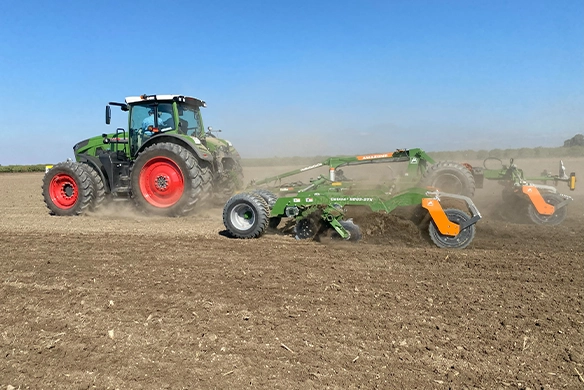 Dynamic field operation of the Amazone Catros+ 9003-2TX attached to a Fendt tractor, showcasing the implement’s width and efficient ground coverage.