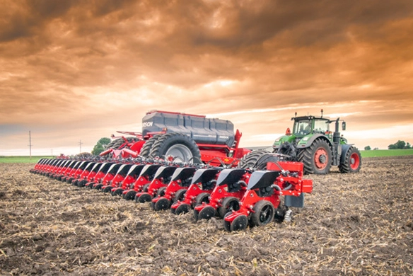 Fendt tractor pulling a HORSCH planter across a freshly tilled field under a dramatic orange sky, showcasing advanced planting equipment in action.