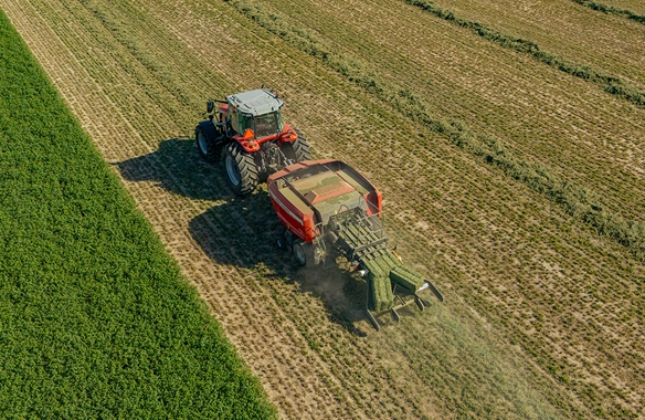 Thumbnail for Aerial view of Massey Ferguson tractor operating a Hesston 1436 Series large square baler in a field, showcasing precision hay collection and efficient baling performance.