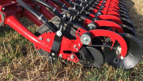 Ground-level view of HORSCH Avatar’s seeding rows with depth control wheels and seed delivery tubes in action during fieldwork.
