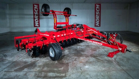 Full view of HORSCH Joker HD cultivator inside a display bay, highlighting hydraulic folding arms, wide discs, and reinforced frame design.
