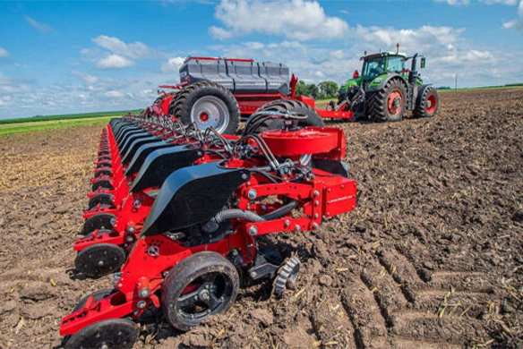 Fendt tractor pulling a HORSCH Maestro SV planter through a freshly tilled field, showing individual row units and seed delivery mechanisms in action.