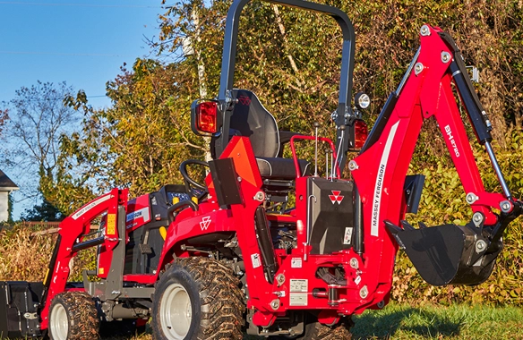 Massey Ferguson 1GC Series compact tractor with backhoe and front loader parked on grass.