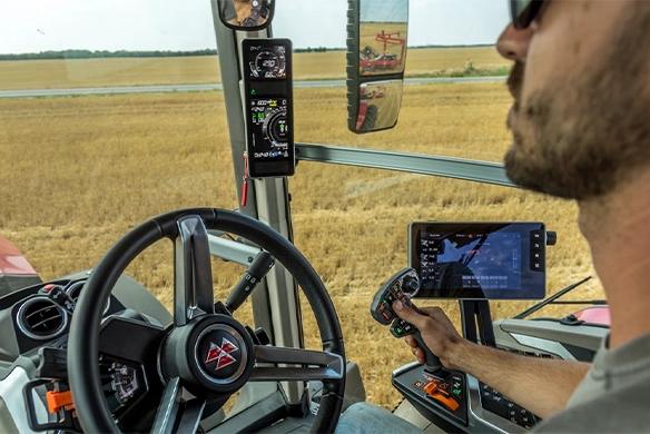 Farmer looking out over his field as MF Guide data is displayed on the screen.