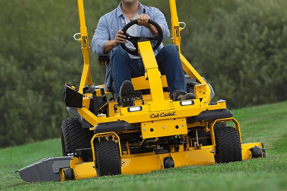 Person operating a Cub Cadet riding lawn tractor on a residential lawn
