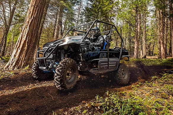 Kawasaki Teryx 2-passenger side-by-side riding off-road in wooded trail
