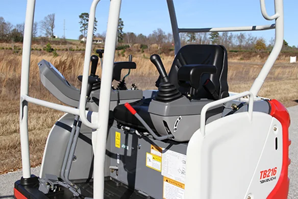 Thumbnail for Close-up of Takeuchi TB216 operator controls, highlighting dual joystick system and ergonomic seat.