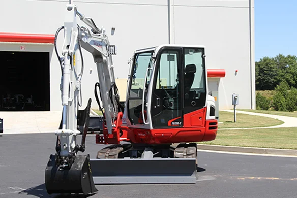 Takeuchi TB250-2 mini excavator shown with dozer blade lowered on asphalt surface.