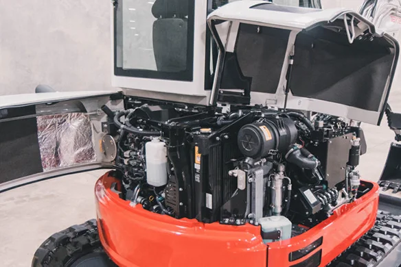 Close-up of Takeuchi TB350R engine bay with open panels, showing maintenance access in a clean service area.
