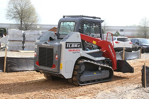 Rear view of Takeuchi TLB2R2 loader on construction site, highlighting powerful hydraulics and compact track design.