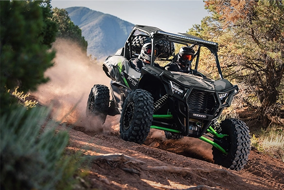 Kawasaki Teryx KRX 1000 side-by-side climbing rugged trail with forest and mountains
