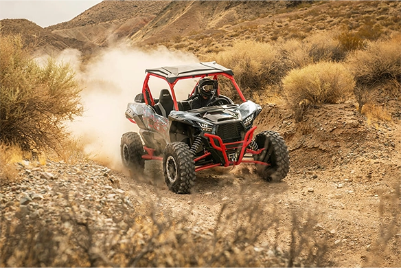 Kawasaki Teryx KRX 1000 off-road vehicle driving through rocky desert terrain