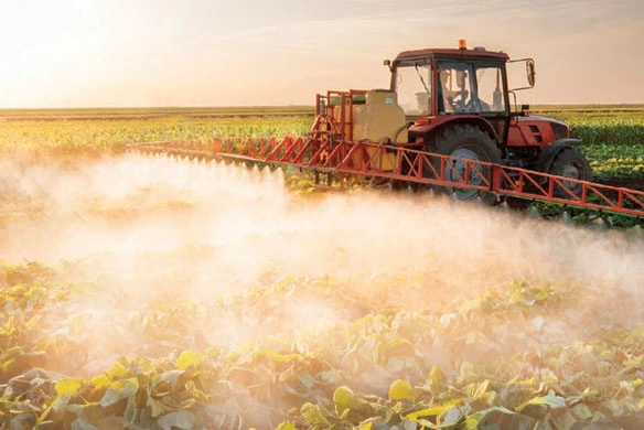 An ag sprayer depositing crop protection chemicals over a planted field.
