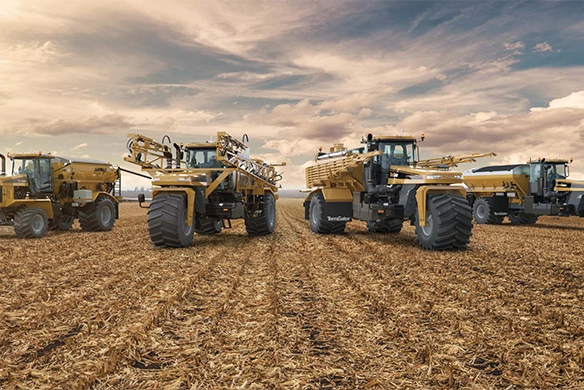 Lineup of TerraGator applicators in a harvested cornfield under cloudy sky