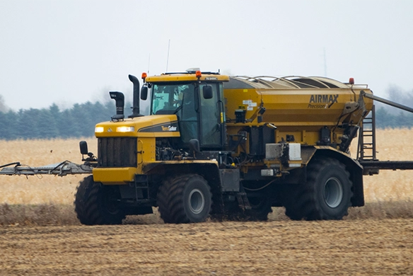 TerraGator AirMax dry spreader working in a harvested corn field with applicator arms extended.