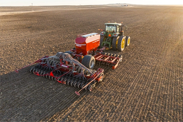 Overhead view of a Horsch air seeder planting across a large, open field with even row spacing and firm seedbed.