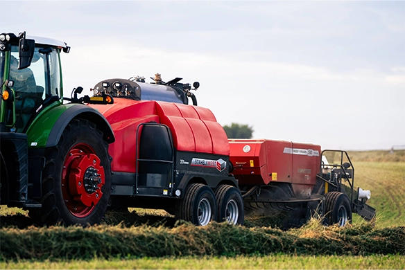 Staheli West 331 steaming system operating in-field behind a large square baler.