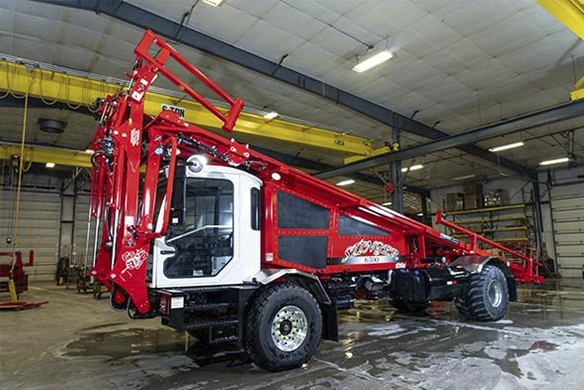 Stinger 6500 bale stacker parked inside a maintenance facility.