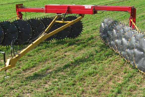 DARF 1017 rake being pulled by a red Jeep during hay raking operation