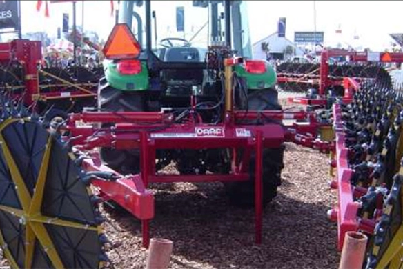 Rear view of DARF 915BRP rake attached to green tractor at outdoor trade show