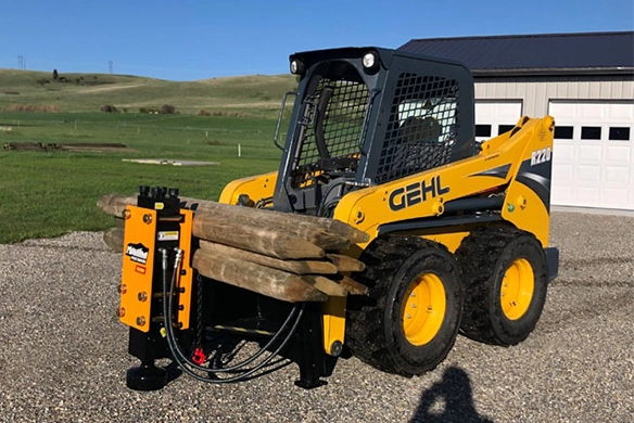 Montana Post Driver 1000E equipped on a GEHL skid steer carrying multiple wooden posts.