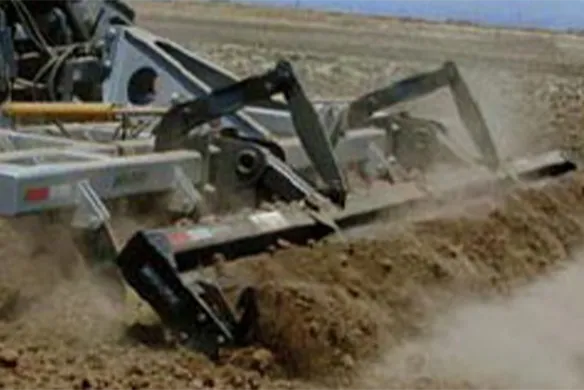 Wilcox pull-type finishing chisel in action, breaking up compacted soil and crop residue for improved seedbed preparation in dry field conditions.