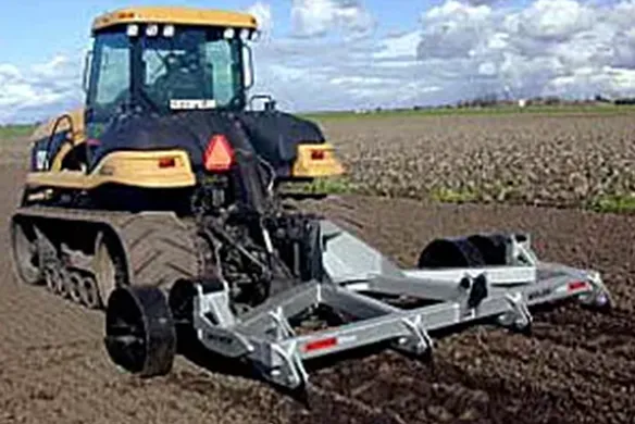 Wilcox 2000 Series 3-point chisel ripper working behind track tractor, engineered for primary tillage and deep soil penetration in compacted fields.