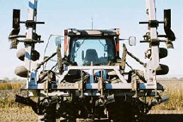 Wilcox folding bar system in vertical transport position behind tractor, designed for compact travel and wide-field coverage.
