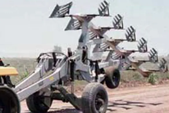 Wilcox hitch carrier towing a multi-bottom plow in transport position, engineered for safe road travel and efficient field transitions.