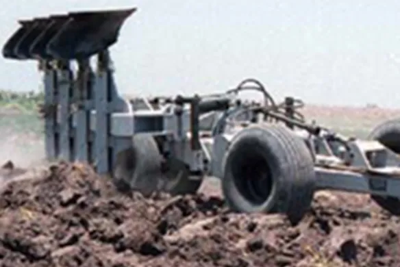 Wilcox hitch carrier supporting mounted plow during active tillage, optimizing traction and stability for deep soil turning in tough field conditions.