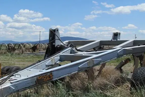 Wilcox hitch frame parked in open field, showing reinforced design for connecting high-demand agricultural implements and plows.