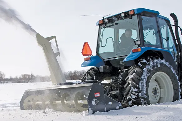 Farm King Allied tractor-mounted snowblower delivering controlled snow removal in winter field conditions
