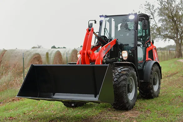 Manitou articulated loader equipped with a bucket for agricultural material handling and property maintenance