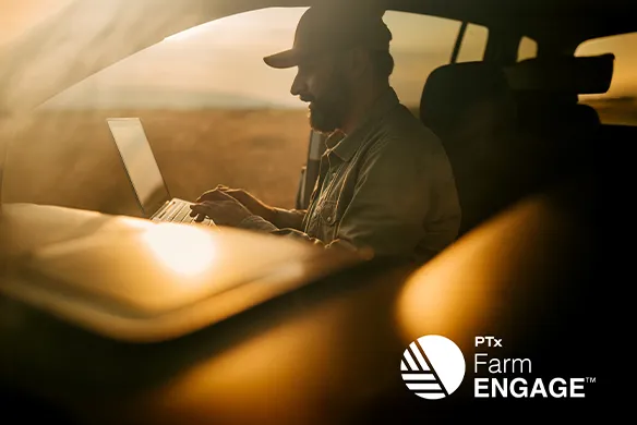 Farmer sitting in his truck reviewing data provided by PTx FarmENGAGE.