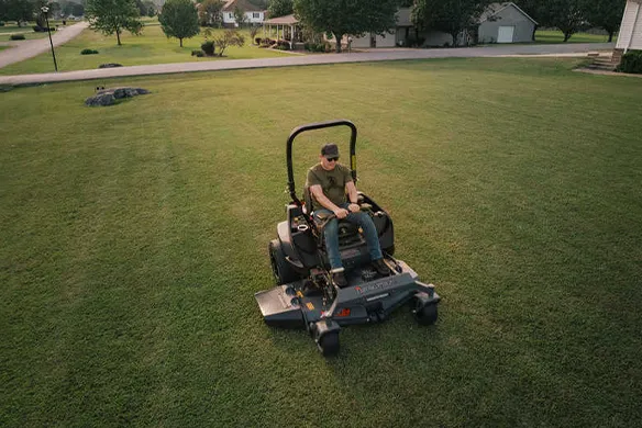 Aerial view of a Spartan SRT-XDe zero-turn mower mowing a large open lawn with efficiency and precision