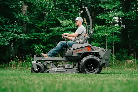 Side profile of a Spartan Defender zero-turn mower delivering stable, efficient mowing across open residential lawn areas