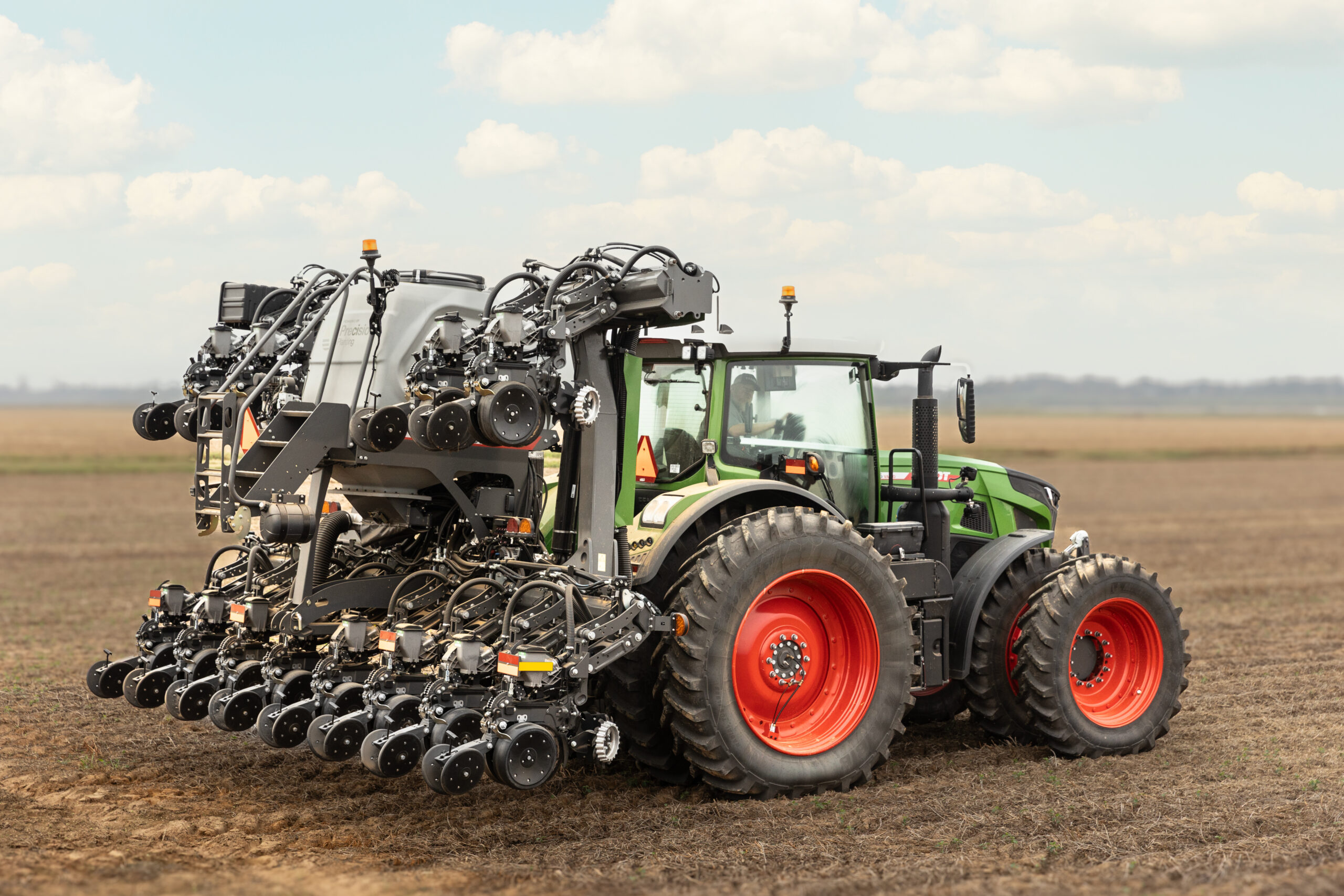 Fendt Optimum planter attached to a tractor in a field.