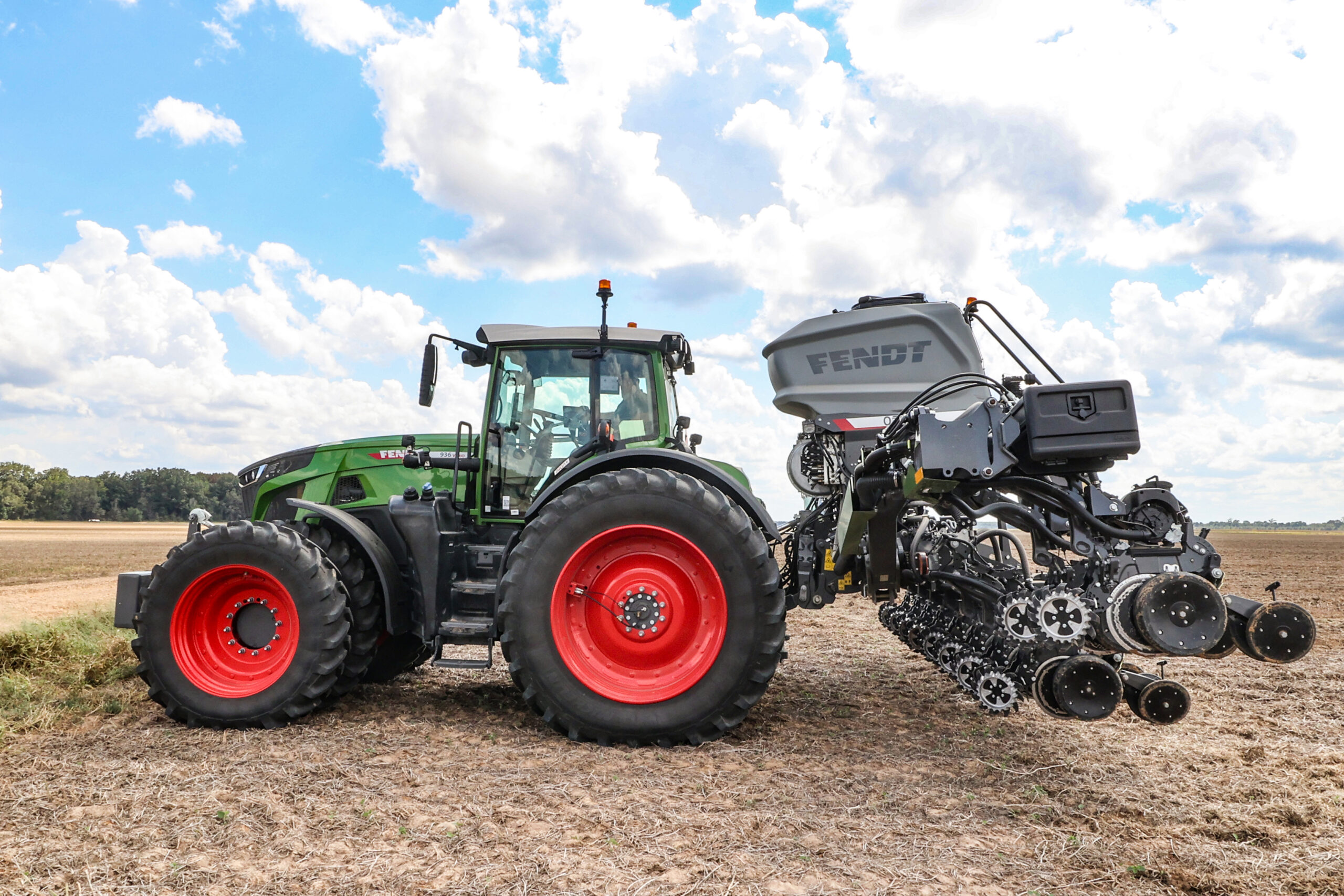 Side view of a Fendt tractor with a Fendt Optimum planter in a field.