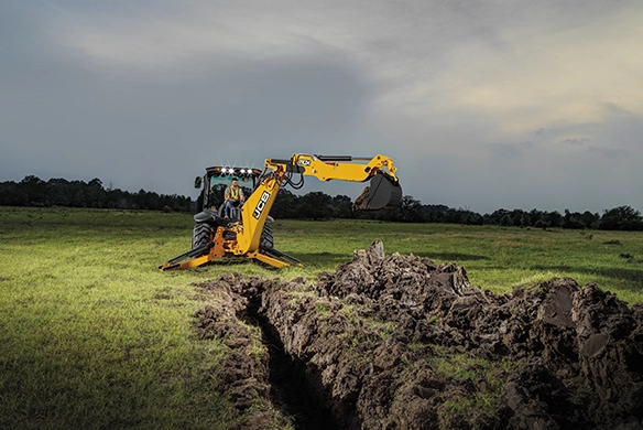 JCB 3CX backhoe loader excavating a trench on open ground