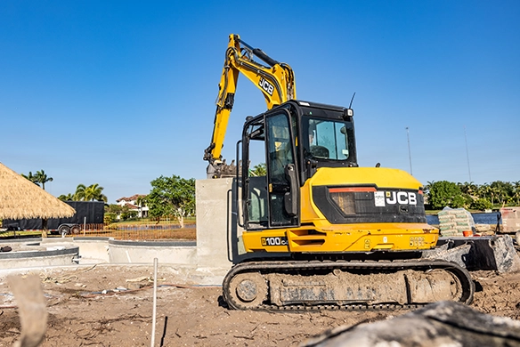 Side view of JCB 100Z-1 mini excavator operating on a construction site with tracked undercarriage