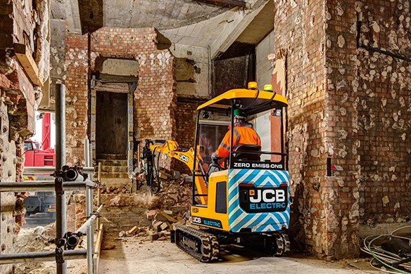 Rear view of JCB 19C-1E electric mini excavator operating indoors with electric power