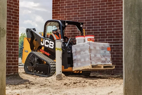 JCB 215T compact track loader moving construction supplies in a tight-access work area