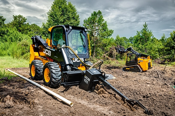 JCB 270 skid steer loader fitted with trencher attachment carrying out groundworks